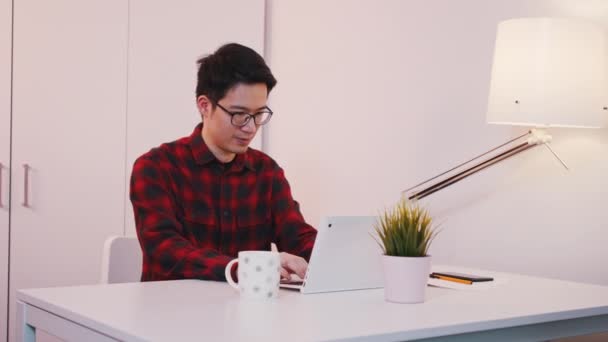Joven asiático estudiante en casa oficina celebrando bueno marca en asignación — Vídeos de Stock