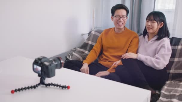 Šťastný asijský pár nahrává video na dslr kameru. Zobrazení palce nahoru — Stock video