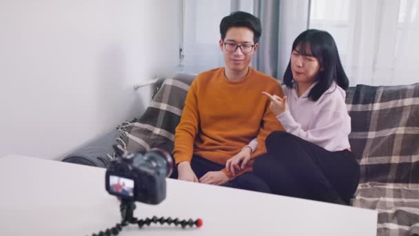 Jovem casal asiático de influenciadores falando e gravando mensagens de vídeo ou streaming nas mídias sociais — Vídeo de Stock