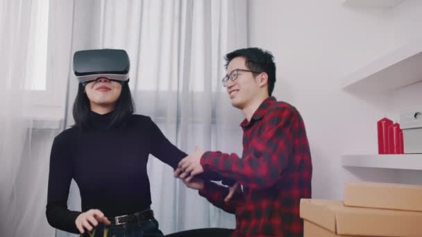 若いアジアのカップルが楽しんでいます。vrゴーグルを身に着けている女性と男ありますタッピング彼女に肩 — ストック動画