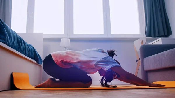 Ung afrikansk kvinna tränar på yogamattan i sitt sovrum — Stockfoto