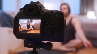 Genç beyaz adam meditasyon yapıyor ve online sınıfa kayıt yapıyor.