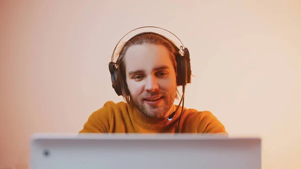 Portrait of young man with headphones winning the game. Game playing on laptop — Stock Photo, Image