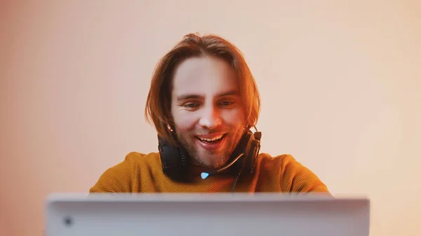 Portrait of young man with headphones winning the game. Game playing on laptop — Stock Photo, Image