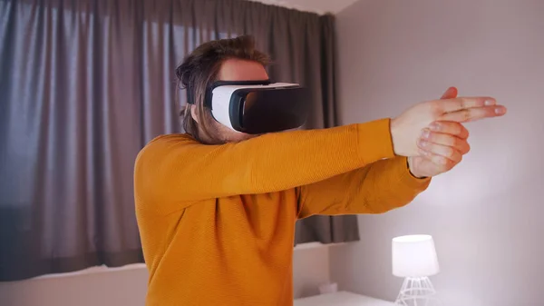 Młody mężczyzna w okularach VR udający, że strzela rękami — Zdjęcie stockowe