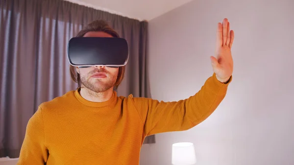 Mladý muž s VR sluchátky zažívá virtuální realitu — Stock fotografie