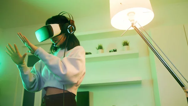 Young woman with VR headset experiencing Virtual world for first time