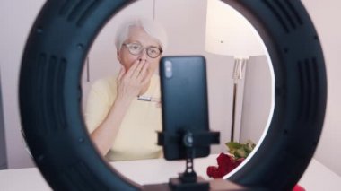 Makyaj yaparken ve sevgililer günü randevusuna hazırlanırken yaşlı bir kadın video görüşmesi yapıyor.