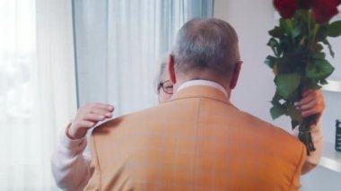 Sevgi ve mutluluk. Yaşlı bir adam, kadınlar gününde karısına kırmızı güller veriyor.