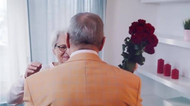 Feliz Dia dos Namorados. Um homem a dar rosas vermelhas à mulher. Casal de idosos em um encontro — Vídeo de Stock