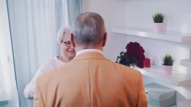 Feliz dia das mulheres. Homem idoso presenteando sua esposa com rosas vermelhas — Vídeo de Stock