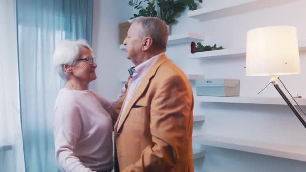 Счастливая пожилая пара танцует дома в официальной одежде. Любовь и знакомства в старости — стоковое видео