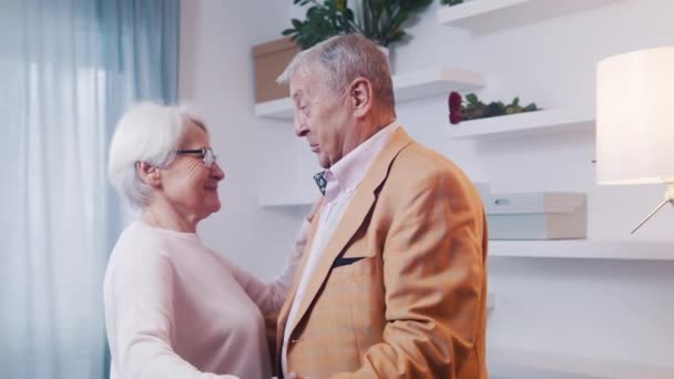 Szczęśliwa para starszych ludzi tańczy w pokoju hotelowym. Miłość i randki na starość — Wideo stockowe