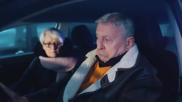Пожилая пара в машине путается с мигающими полицейскими фонарями. Билет на превышение скорости — стоковое видео
