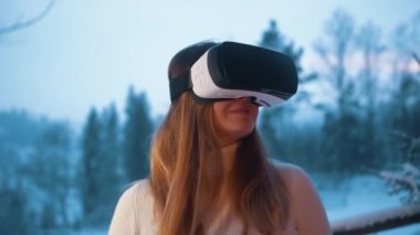 Kışın terasta VR gözlüklü beyaz bir kadın.