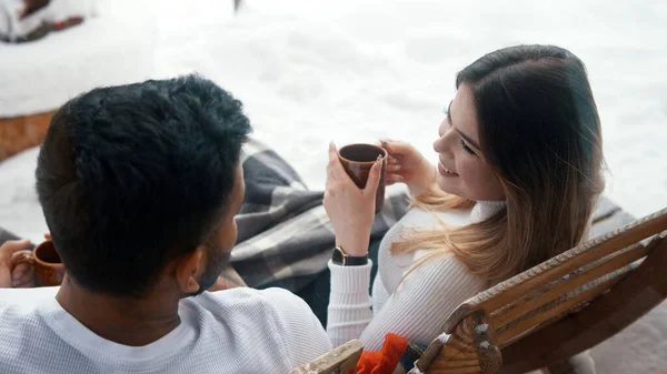 Achteraanzicht. Gelukkig jong stel drinken warme chocolademelk terwijl zitten op de bank buiten op Valentijnsdag — Stockfoto
