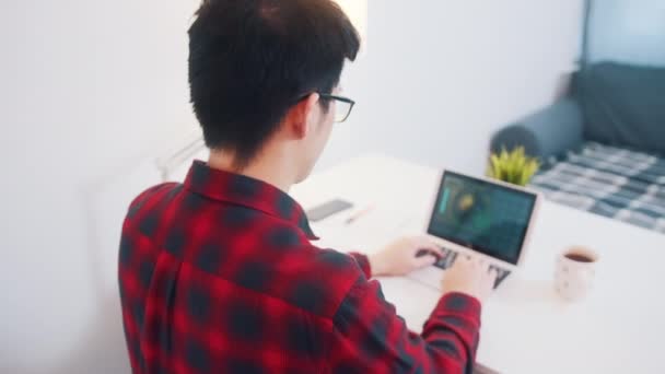 Молодой азиат расслабляется на стуле доволен своей работой — стоковое видео