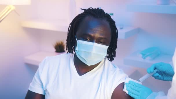 Портрет африканского чернокожего мужчины, получающего вакцину против коронавируса — стоковое видео