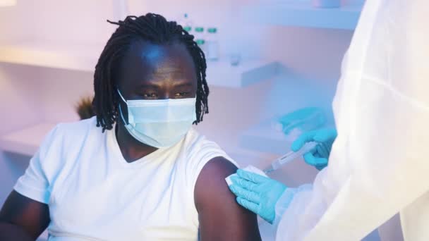 Vaccination et immunisation avec le vaccin ARNm contre le coronavirus. Jeune homme noir afro-américain avec masque facial se faire vacciner — Video