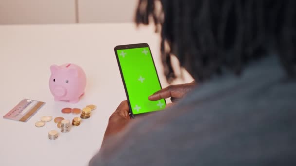 Hombre negro afroamericano utilizando la aplicación móvil para invertir. Pantalla verde en smartphone — Vídeos de Stock
