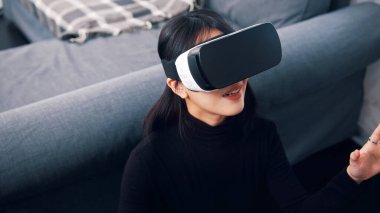 İçerde VR gözlüğü kullanan genç bir kadının portresi.