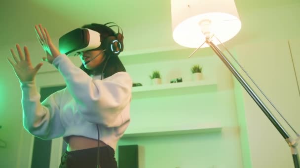 Mladá Asiatka zažívá virtuální realitu. Při pohledu na její ruce — Stock video