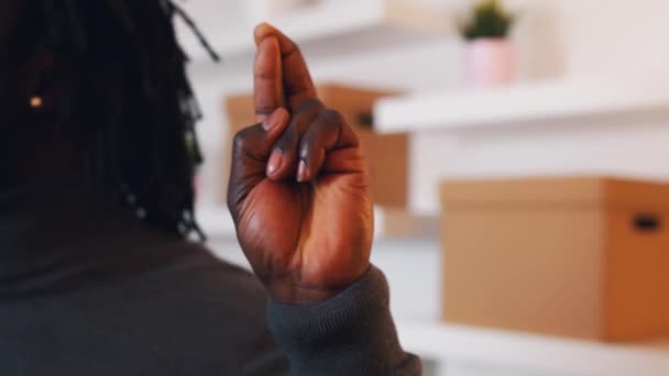 Close up fingers crossed, African American black man holding cross fingers in the new apartment — Stock video