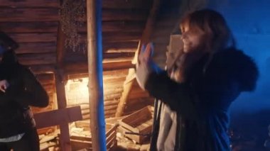 Genç kadınlar ahşap kulübede dans edip yeni yılı kutluyorlar. Kış mevsimi