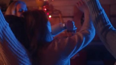 Mutlu genç kadınlar parti veriyor, rahat bir evde dans ediyor, yanıp sönen disko ışıklarıyla. Kış tatili