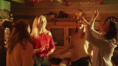 Genç kadınlar parti veriyor, evlerinde dans ediyorlar.