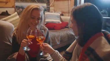Genç lezbiyen çift sıcak şarapla kadeh kaldırıyor.. 