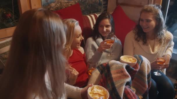 Excited young women spending winter holidays in the cozy home drinking mulled wine and having snacks — 비디오