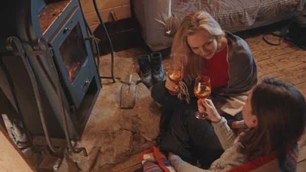 Genç mutlu lezbiyen çift şöminenin yanında kadeh kaldırıyor. Kış tatili kavramı — Stok video