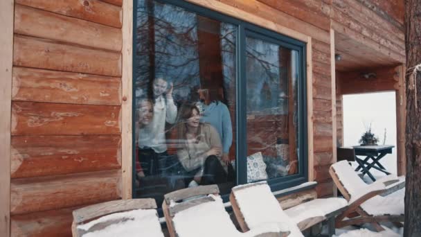 Grupo de mujeres jóvenes divirtiéndose en la casa de madera de montaña rodeada de nieve — Vídeos de Stock