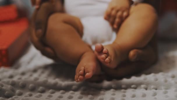 閉じて、赤ちゃんの足。父と息子の絆。アフリカ系アメリカ人の男は子供の頃少し足で遊んでいた — ストック動画