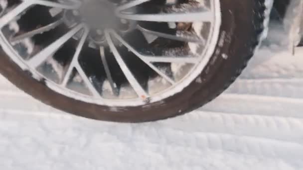 Pneus de inverno fechar em cima de um carro na neve indo para trás — Vídeo de Stock