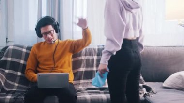 Genç adam dizüstü bilgisayarında oyun oynuyor ve kız arkadaşını görmezden geliyor. Dikkat çekmek isteyen kadın