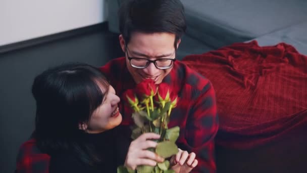 Joven hombre asiático dando rosas rojas a su novia. Feliz día de San Valentín — Vídeos de Stock