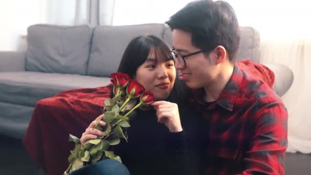 若いアジア人の男が彼女に赤いバラを与えた。ハッピーバレンタインデー — ストック動画