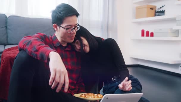 Mutlu genç çift kanepede dinleniyor kucaklaşıyor ve dizüstü bilgisayarda film seyrediyor. — Stok video