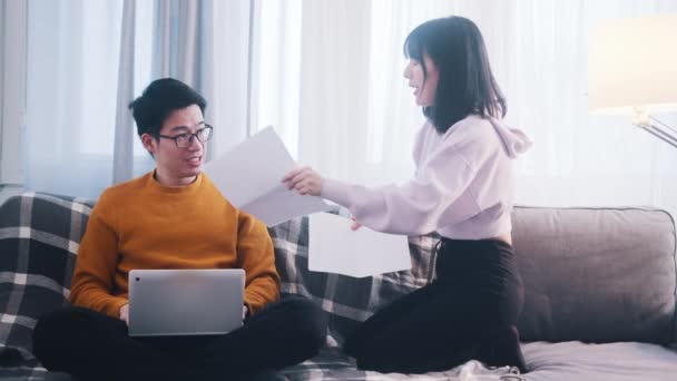 Casal jovem discutindo finanças. Mulher segurando contas enquanto o homem está usando laptop — Vídeo de Stock