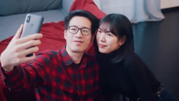 Boldog fiatal ázsiai pár szelfit készít. Vörös rózsát tartó nő — Stock videók
