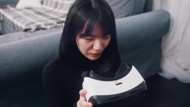 Jeune femme asiatique tenant des lunettes VR et regardant à l'intérieur — Video