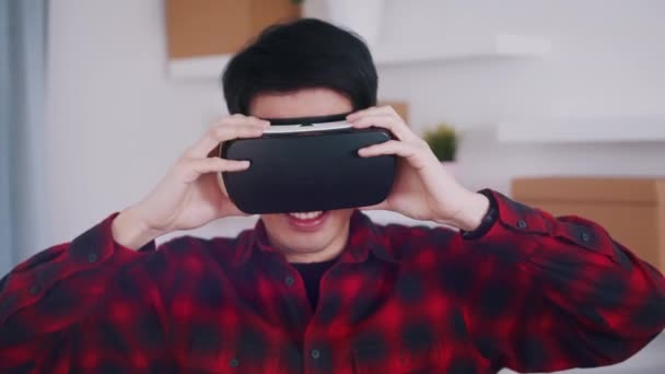 Asiatico giovane uomo rimozione VR auricolare da hs occhi e sorridente — Video Stock