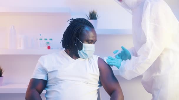 Молодой африканский человек получает вакцину против ковида-19 — стоковое видео