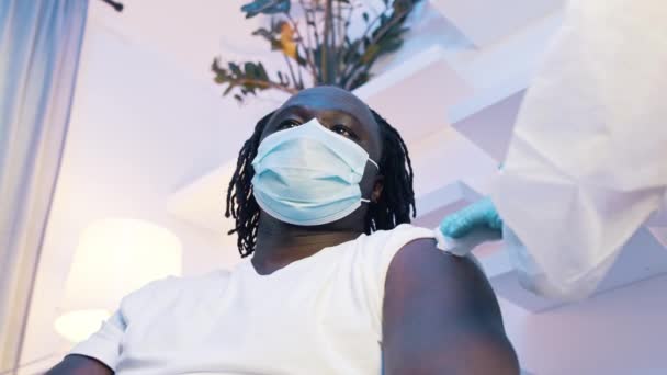 Африканский чернокожий мужчина получает вакцину против covid19. Иммунизация и борьба с пандемией — стоковое видео