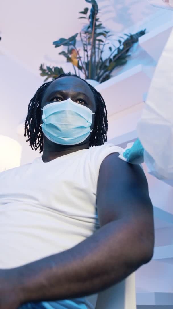 Hombre negro afroamericano vertical que recibe la vacuna contra el covid19. Inmunización y lucha contra la pandemia — Vídeos de Stock