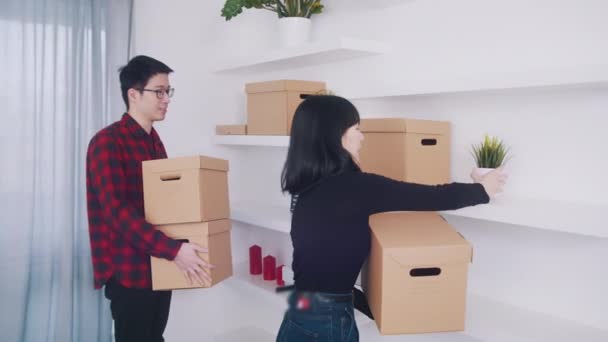 Щаслива молода азіатська пара переїздить в нову квартиру — стокове відео
