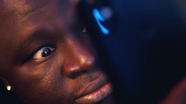 Kapatın, şok olmuş Afro-Amerikan siyahi adam battaniyeye sarılı e-posta okuyor. Kötü haber.