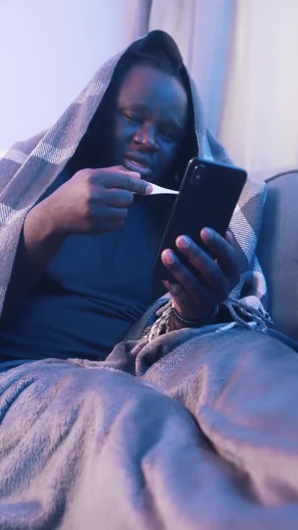 Άτομο με υψηλό πυρετό που καλύπτεται με κουβέρτα έχοντας βιντεοκλήση με γιατρό. Ηλεκτρονική ιατρική υποστήριξη — Αρχείο Βίντεο